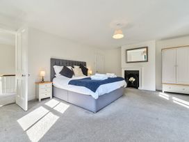 A bedroom with a double bed bedside tables wardrobe and fireplace at Bedingfield House nr Debenham