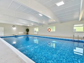 An indoor swimming pool with a diving board and windows at Bedingfield House nr Debenham Debenham