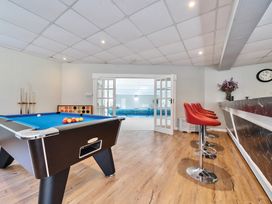 A game room with a pool table red bar stools and a bar counter at Bedingfield House nr Debenham