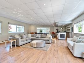 A living room with two sofas a round ottoman and a bar area with stools at Bedingfield House nr Debenham Debenham 