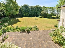 A garden with a lawn and trees surrounding it at Bedingfield House nr Debenham
