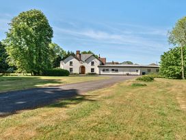 A white house with a driveway and surrounding trees and grass at Bedingfield House nr Debenham in Debenham