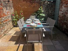 An outdoor dining area with a table set for meals at Seaflower, Aldeburgh