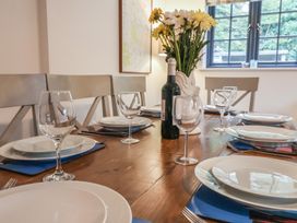 A dining room with a table set for meal at Corner Cottage, Thorpeness