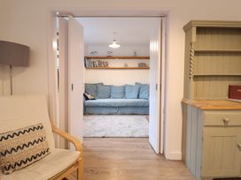 A living room with a sofa and bookshelf at Corner Cottage, Thorpeness