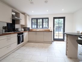 A kitchen with cabinets and appliances at Corner Cottage, Thorpeness
