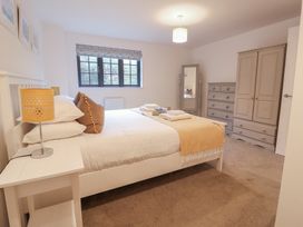 A bedroom with a double bed and furniture at Corner Cottage, Thorpeness