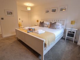 A bedroom with a double bed and nightstand at Corner Cottage, Thorpeness
