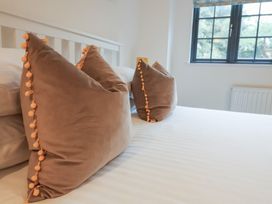 A bedroom with pillows on a bed at Corner Cottage, Thorpeness