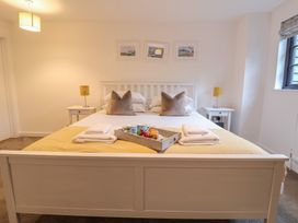 A bedroom with a bed and nightstands at Corner Cottage, Thorpeness