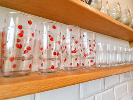 Glasses with strawberry print on a wooden shelf at Fishpond House, Sotherton