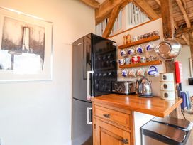 A kitchen with a refrigerator, toaster, kettle, and shelf at Fishpond House, Sotherton in Halesworth