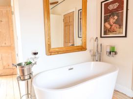 A bathroom with a bathtub and a mirror at Fishpond House, Sotherton