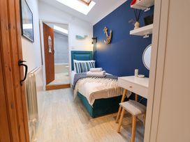 A bedroom with a bed and desk at The Smokehouse Cottage in Southwold