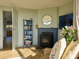 A living room with a bookshelf and a fireplace at Harbour Lights in Southwold