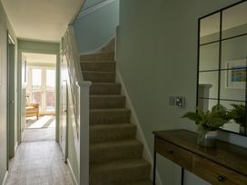 A hallway featuring a staircase and table at Harbour Lights in Southwold