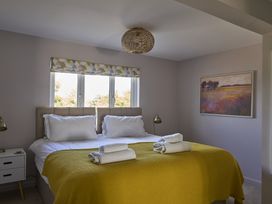 A bedroom with a double bed and windows at Harbour Lights in Southwold