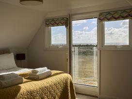 A bedroom with a bed and towels at Harbour Lights in Southwold