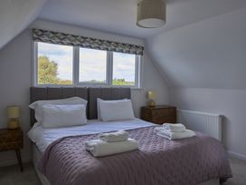 A bedroom with a bed and windows at Harbour Lights in Southwold