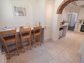 A kitchen with bar stools and kitchen cabinets at High Ground, Reydon