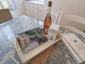 A dining room table with a tray containing a bottle, visitors book, and biscuits at High Ground, Reydon