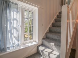 A staircase with a window and curtain at High Ground, Reydon