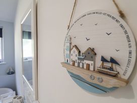 A decorative wall art and mirror in a bathroom at High Ground, Reydon