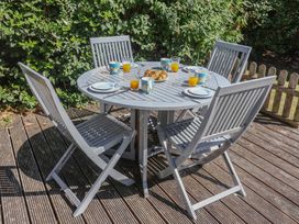 A garden dining table with cups and plates at High Ground, Reydon