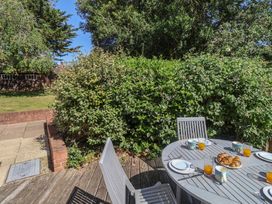 A garden with a table set for breakfast at High Ground, Reydon