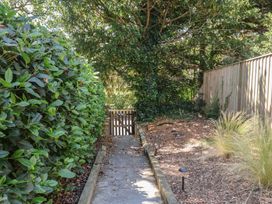 A garden path with a gate surrounded by hedges at High Ground in Reydon