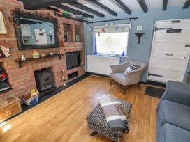 A living room with a fireplace and sofa at Cherry Tree Cottage, Woodbridge