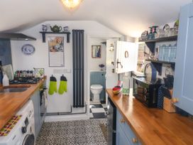 A kitchen with a stove, sink and cupboards at Cherry Tree Cottage, Woodbridge