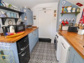 A kitchen with appliances and shelves at Cherry Tree Cottage, Woodbridge