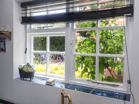 A window with blinds and plants outside at Cherry Tree Cottage, Woodbridge