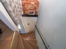 A staircase with a handrail and framed picture at Cherry Tree Cottage, Woodbridge