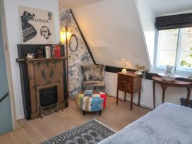A bedroom with a fireplace and chair at Cherry Tree Cottage, Woodbridge