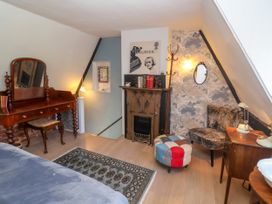 A bedroom with a vintage vanity and ornate fireplace at Cherry Tree Cottage, Woodbridge
