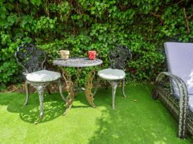 A garden with two chairs and a table with mugs at Cherry Tree Cottage, Woodbridge