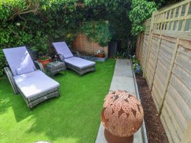 A garden with sun loungers and a fire pit at Cherry Tree Cottage, Woodbridge