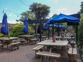 An outdoor seating area with tables and umbrellas at Cherry Tree Cottage in Woodbridge