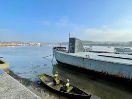 A landscape with boats and figures near water at Cherry Tree Cottage, Woodbridge