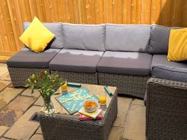 An outdoor seating area with a sofa and coffee table at 11 Crabbe Street, Aldeburgh