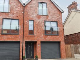 A brick house with multiple windows and a garage door at Salt Marsh House, Southwold