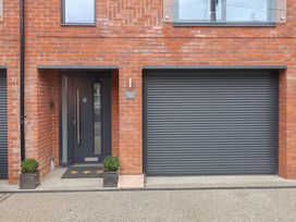 A front entrance with a door and garage door at Salt Marsh House, Southwold