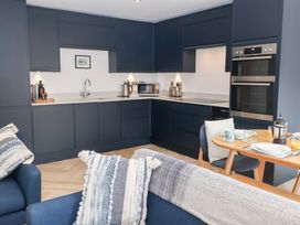 A kitchen with modern appliances and dining table at Salt Marsh House, Southwold