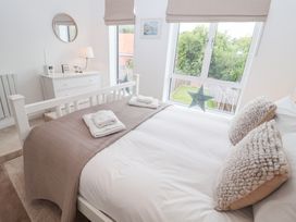 A bedroom with a bed and dresser at Salt Marsh House, Southwold