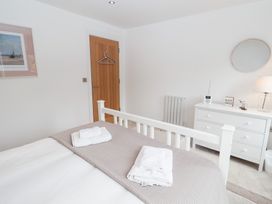 A bedroom with a bed and dresser at Salt Marsh House, Southwold