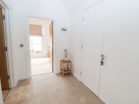 A hallway with a door and decorative items at Salt Marsh House, Southwold