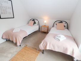 A bedroom with two single beds and a nightstand at Salt Marsh House, Southwold
