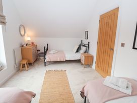 A bedroom with two beds and a dressing table at Salt Marsh House, Southwold